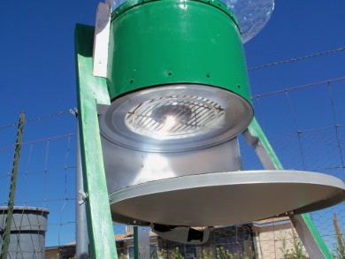 Looking up into Art's hybrid solar oven from to where the parabolic
      dish reflects the sunlight onto a black painted pot.