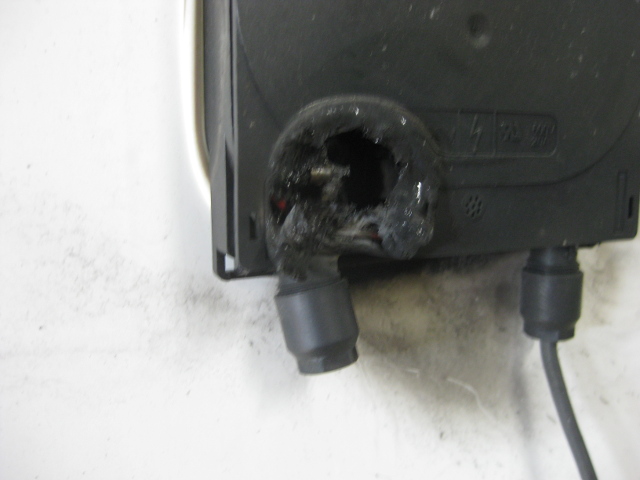 Close-up of the hole melted by lightning damage in the plastic box behind the solar panel.