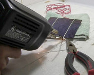 Soldering negative to solar cell.