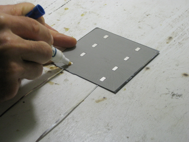 Putting flux on the back of a solar cell before soldering two solar cells together.
