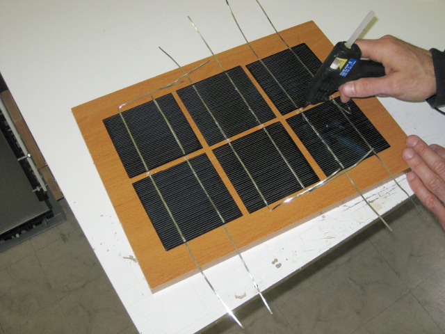 Gluing the solar cells to the wooden backing.