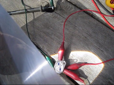 Focusing sunlight on the transistor solar cell using a small Fresnel lens.