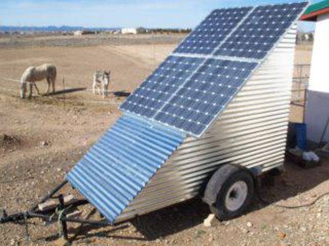 Lower solar panels removed from mobile off-grid solar power system trailer for transport.