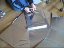 Cutting aluminum foil for a panel
        of the Modified CooKit solar cooker.