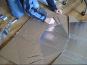 Applying glue to a panel of the
        Modified CooKit solar cooker.
