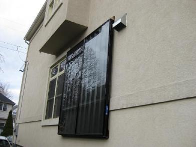 A two-SolarSheat installation on the side of a house.</a>
