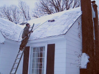 Using a roof rake to remove snow.