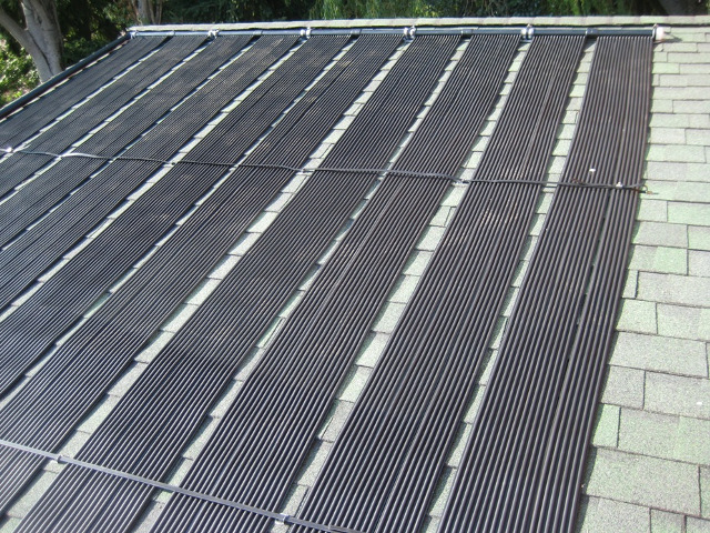 Solar heat collector panels on a roof for a DIY installation of a commercial solar pool heater in Seattle.