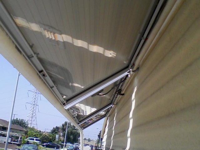 Another angle under RV solar panels, showing the frame mounting screws.