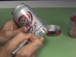 Cutting the bottoms from the cans for the alcohol stove.
