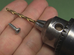 A drill beside a screw.