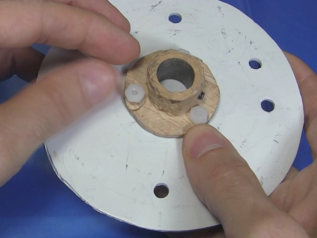 Using nuts and bolts to attach a wooden hub to the center of a disk.