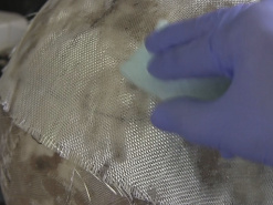 Applying resin onto the fiberglass.