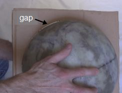 Checking roundness of the fiberglass ball by putting it in a cardboard circle.