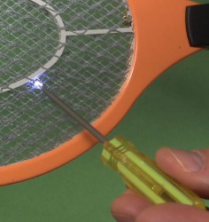 Making a spark in an electric fly swatter with a screw driver.