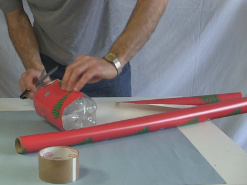 Wrapping the bottle rocket with wrapping paper.