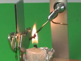 Photo of the curie temperature experiment with a piece of nickel in a candle flame in a magnetic field.