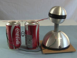 A Franklin's bell made from two soda cans and the tab from a can and being powered by a small Van de Graaff generator.