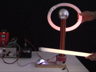 A tesla coil with glowing fluorescent tubes around it.
