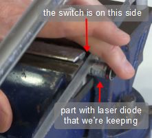Cutting the laser pointer cylinder to expose the laser diode inside.