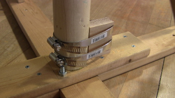 The bottom of the pole hose clamped to the wooden block.