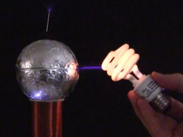 Compact fluorescent lamp powered by a spark gap Tesla coil.