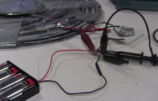 Closeup of the oscilloscope probes at the battery inputs.