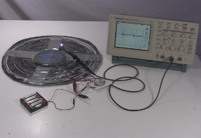 The full setup with oscilloscope for measuring the output voltage of the wireless transmission of electricity.