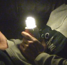 Holding a CFL powered by a joule thief in my hand in the dark.