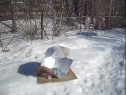 Modified CooKit solar cooker being used to 
      cook the soya rice vegetable concoction in the winter snow.