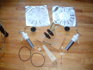 The Wimshurst machine disassembled showing all the parts spread out.