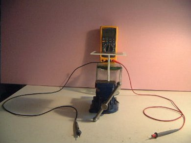 The setup of measuring the capacitance of a paraffin wax 
      dielectric capacitor with a digital multimeter (DMM).