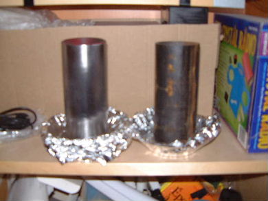 Two electrets wrapped in aluminum foil sitting on a shelf.