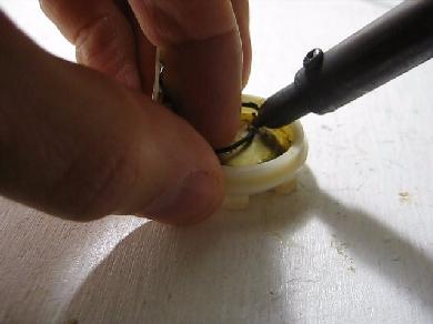 Desoldering the wires from the piezoelectric disk.