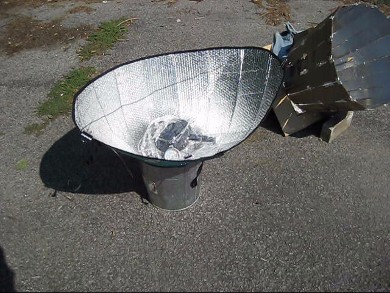 Car shade solar cooker sitting in a garbage can or bucket/pail.