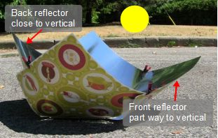 Copenhagen solar cooker reflector panels adjusted for a high 
      sun angle, around midday.