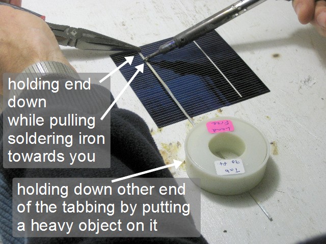 Soldering two solar cells together.