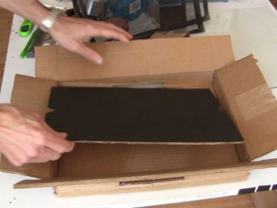 A black painted piece of cardboard was placed in the back of the mini screen solar air heater.