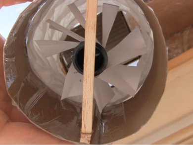Close-up of the paper turbine in its housing attached to the mini screen solar air heater's cold air inlet.