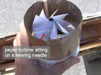 Close-up of the paper turbine in its housing attached to the mini screen solar air heater's hot air outlet.