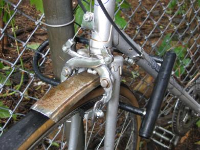 The bicycle lock locking the bike to a fence post.