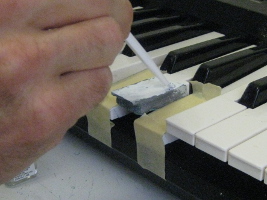 Painting the repaired piano/keyboard key.