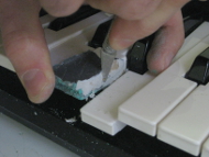 Scraping cardboard sides of the mold for the piano/keyboard key.