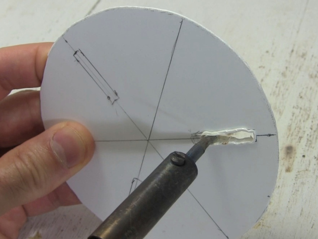 Melting slots in a plastic disk using a soldering iron.