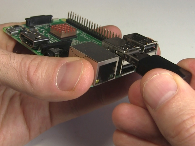 Plugging the WiFi dongle into the Raspberry Pi's USB port.