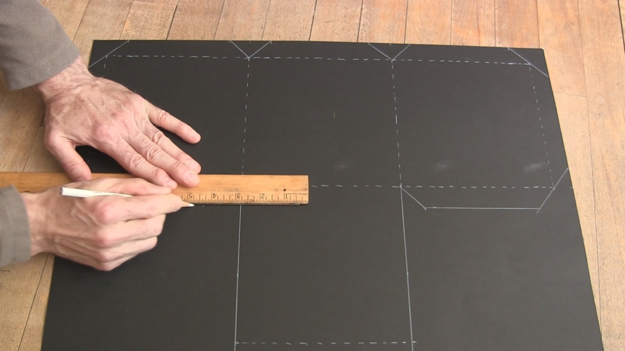 Drawing the lines on the poster board for the pinhole camera.