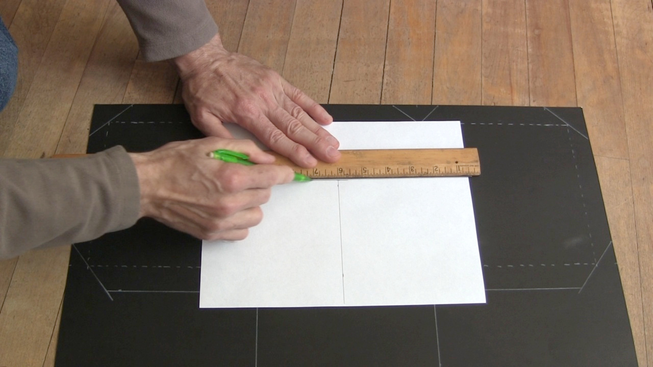 Drawing out the sheet for the pinhole camera's screen on a sheet of white paper.