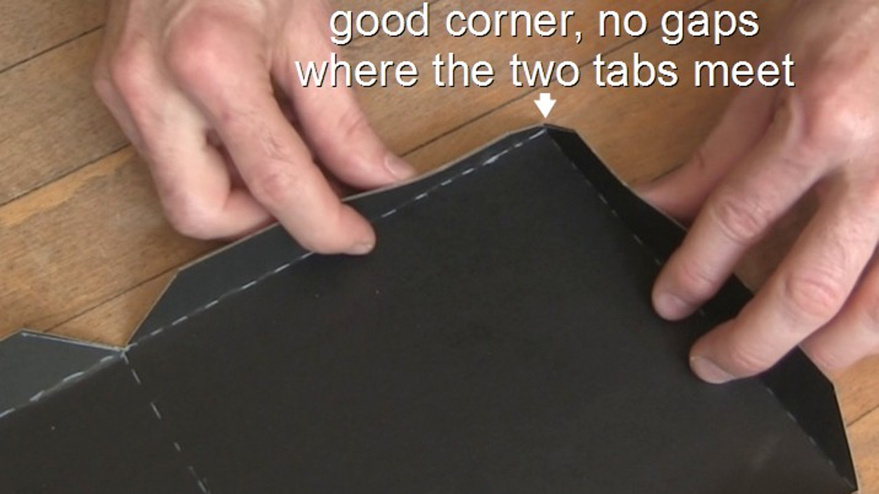 Showing a corner where the tabs are bent up such that the corners meet and no light will leak into the pinhole camera.