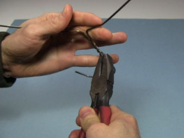 Taking apart the clothes hander wire using pliers.