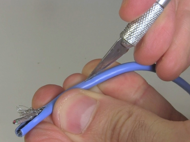 Making a slit in the cable's jacket using a knife.